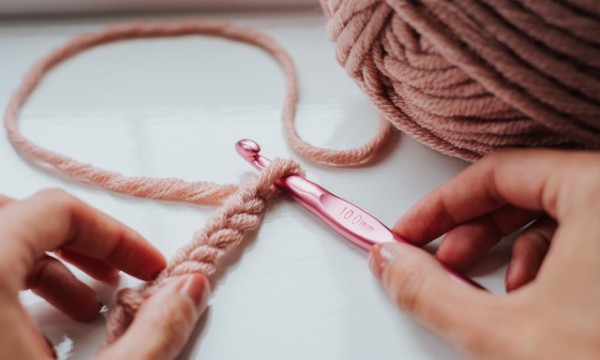 Hands with crochet hook and yarn, photographed by Anete Lusina